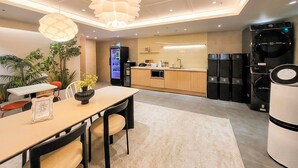 A modern kitchen with a central island, built-in appliances, and a dining area with a table and chairs. - 4rest Stay Jongno (Seoul)