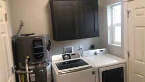 A laundry room with a washer, dryer, and a water heater.
