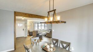 A dining area with a wooden table, chairs, and a chandelier. - Cozy Home Near Table Rock & Eureka Springs (Holiday Island)