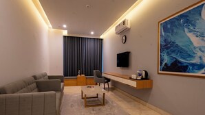 Ein modernes Wohnzimmer mit Sofa, Couchtisch, Fernseher und Kunstwerken.