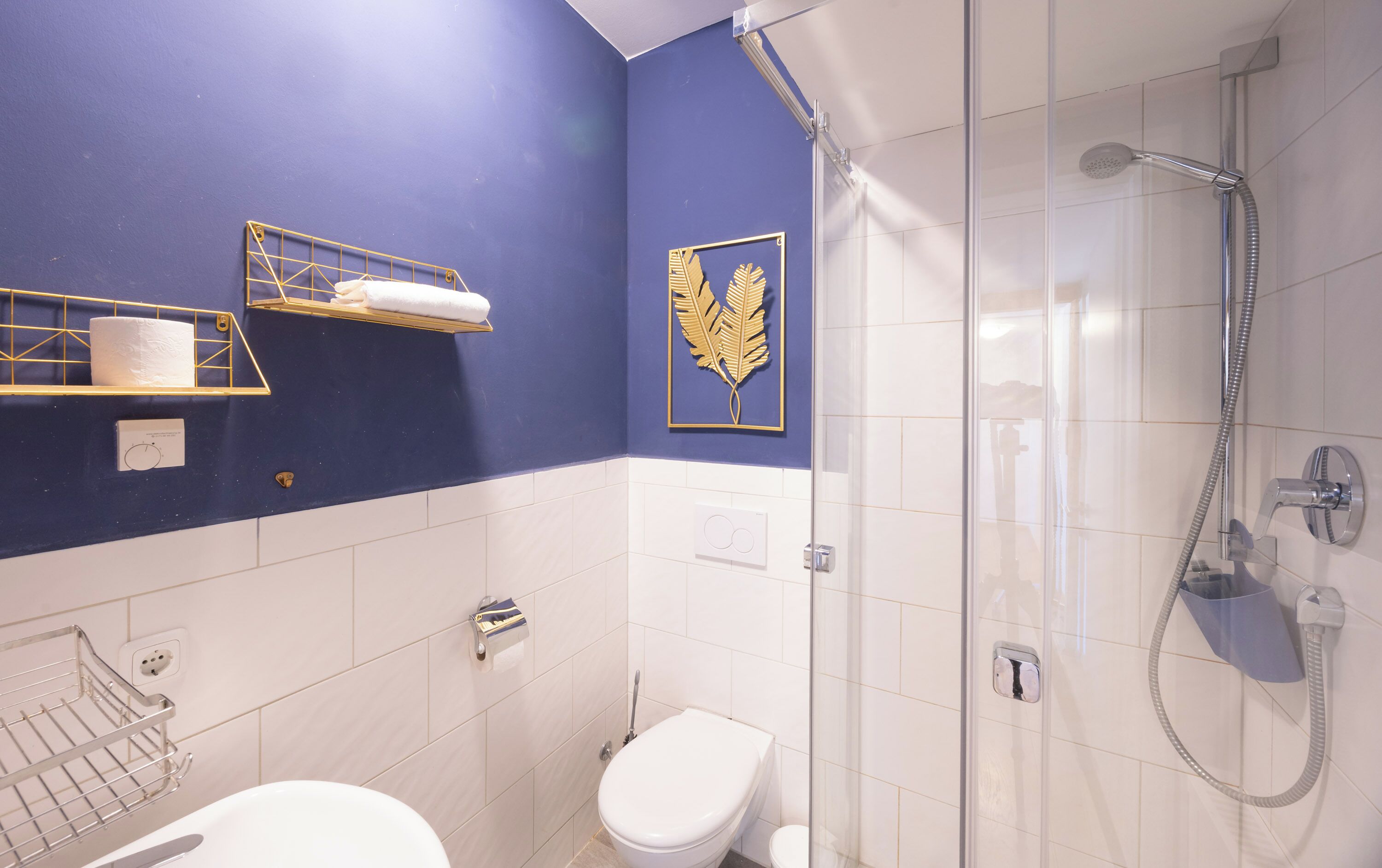 Une salle de bain avec douche, toilettes et lavabo.