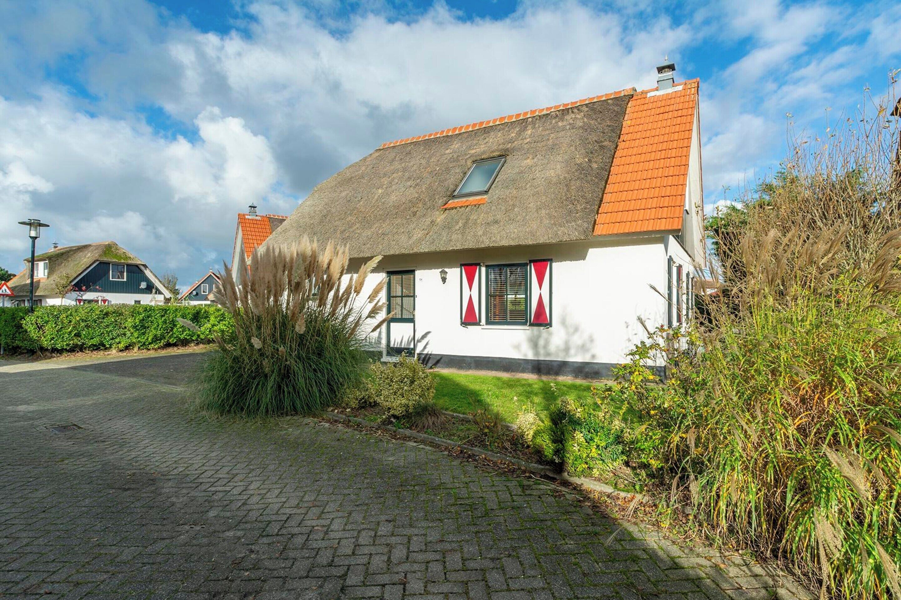 A traditional house with a sloped roof and a small window.