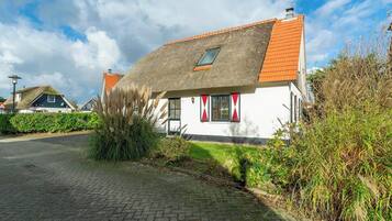 A traditional house with a sloped roof and a small window.