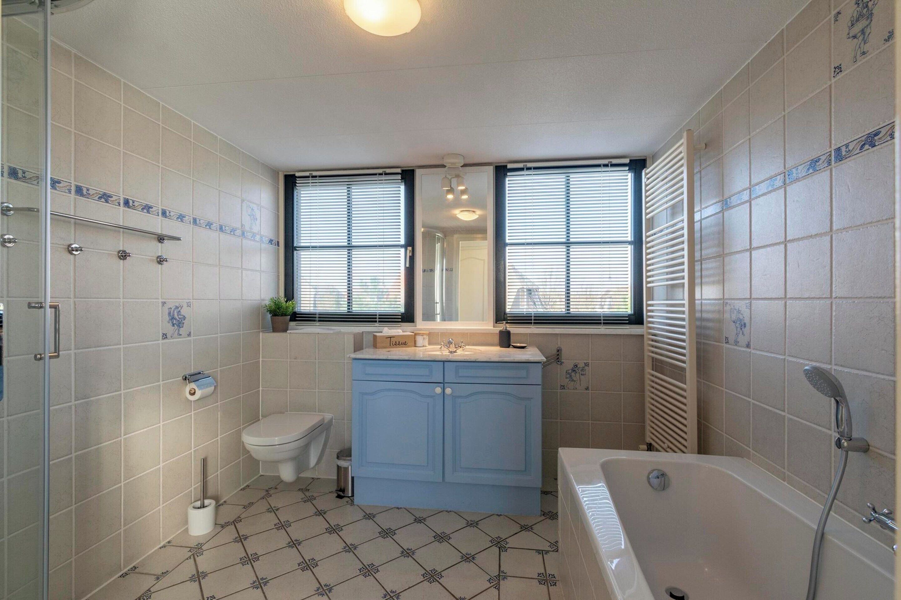 A bathroom with a toilet, sink, and bathtub.