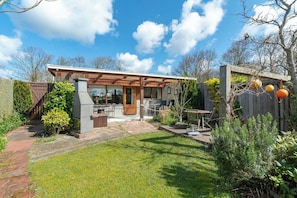 A modern house with a patio, a barbecue area, and a wooden fence. - Wildrijk 152 Holiday Home in Sint Maartenszee (Sint Maartensvlotbrug)