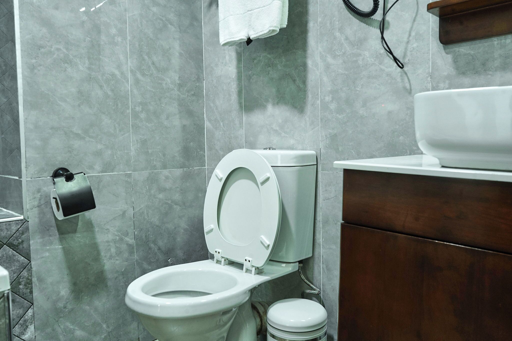 Un baño con inodoro, lavamanos y espejo.