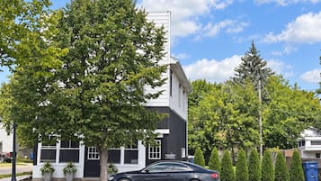 A modern building with a black and white facade, a parked car, and a clear blue sky.