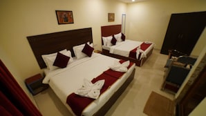 A hotel room with two beds, each with white linens and red accents, a wooden headboard, and a red curtain. - Hotel V Platina  (Bhubaneshwar)
