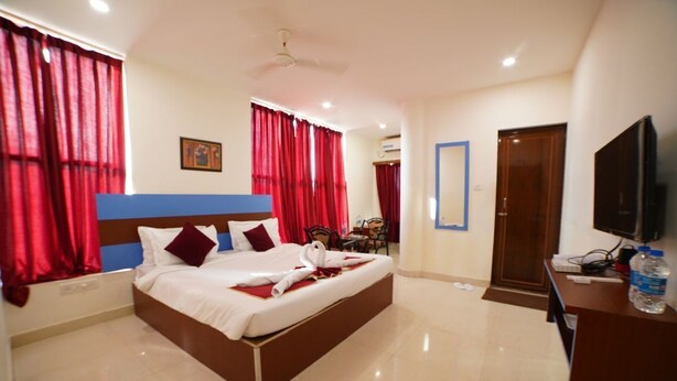 A hotel room with a bed, a desk, a television, and a mirror. - Hotel V Platina  (Bhubaneshwar)
