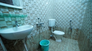 A bathroom with a sink, toilet, and shower. - Hotel V Platina  (Bhubaneshwar)