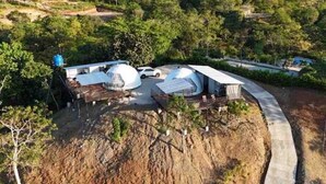 A modern eco-lodge with dome-shaped cabins, a dirt path, and lush greenery. - Dome 1 Potrero Beach | Natural Getaway with Ocean View and Private Jacuzzi (Potrero)