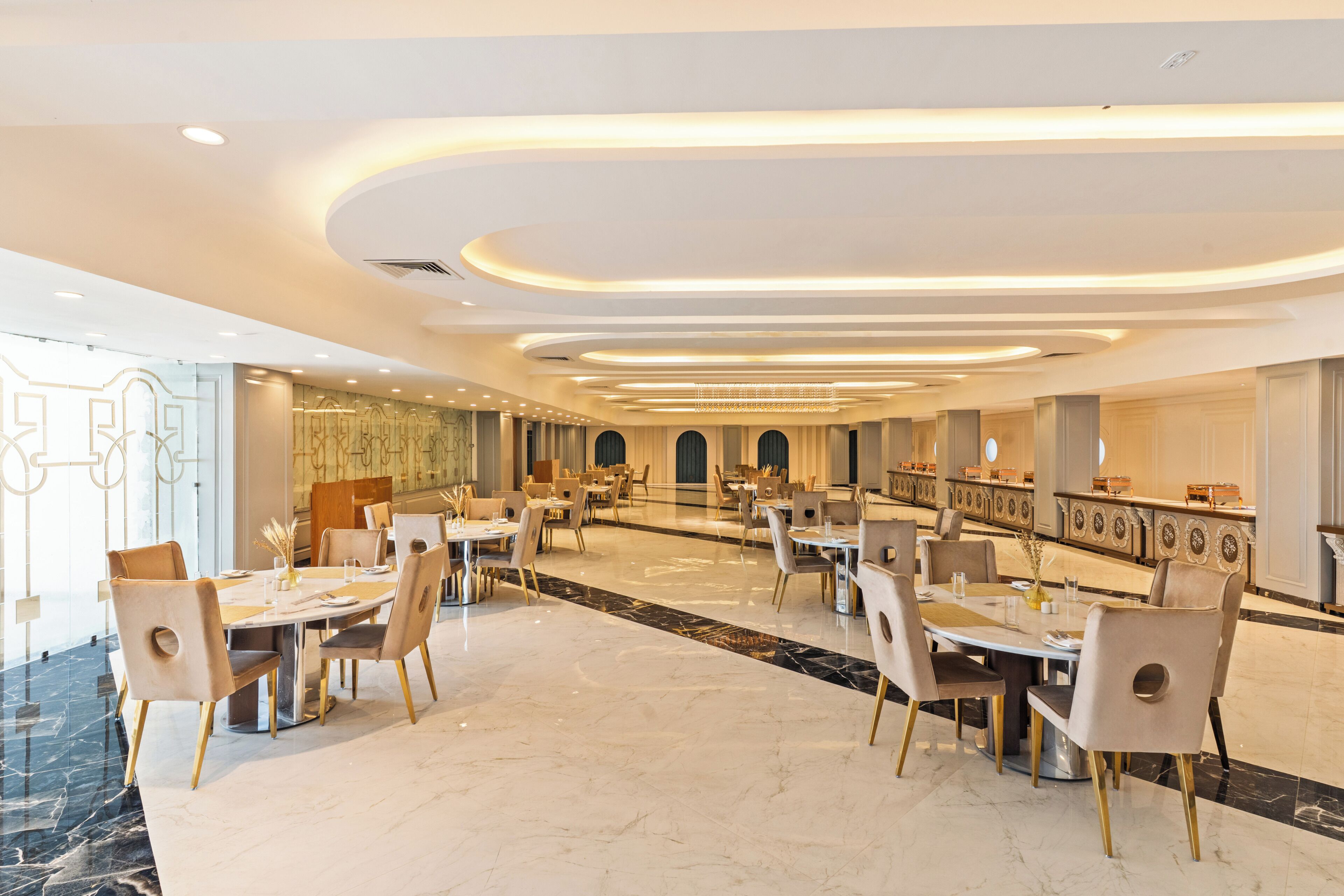 A spacious dining area with marble flooring, modern chairs, and a long table.