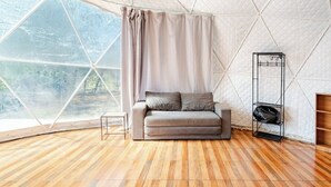 A room with a geometric ceiling, a sofa, a small table, and a shoe rack. - Glamping Dome Potrero Nº 4: Space, Nature and Comfort with Private Pool (Potrero)