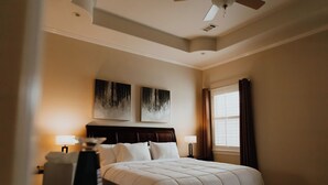 A hotel room with a bed, two bedside lamps, a ceiling fan, and artwork on the wall. - Sleek Ardmore Home, near lake Murray, Mercy Hospital, Lakecrest, Winstar casinos (Ardmore)