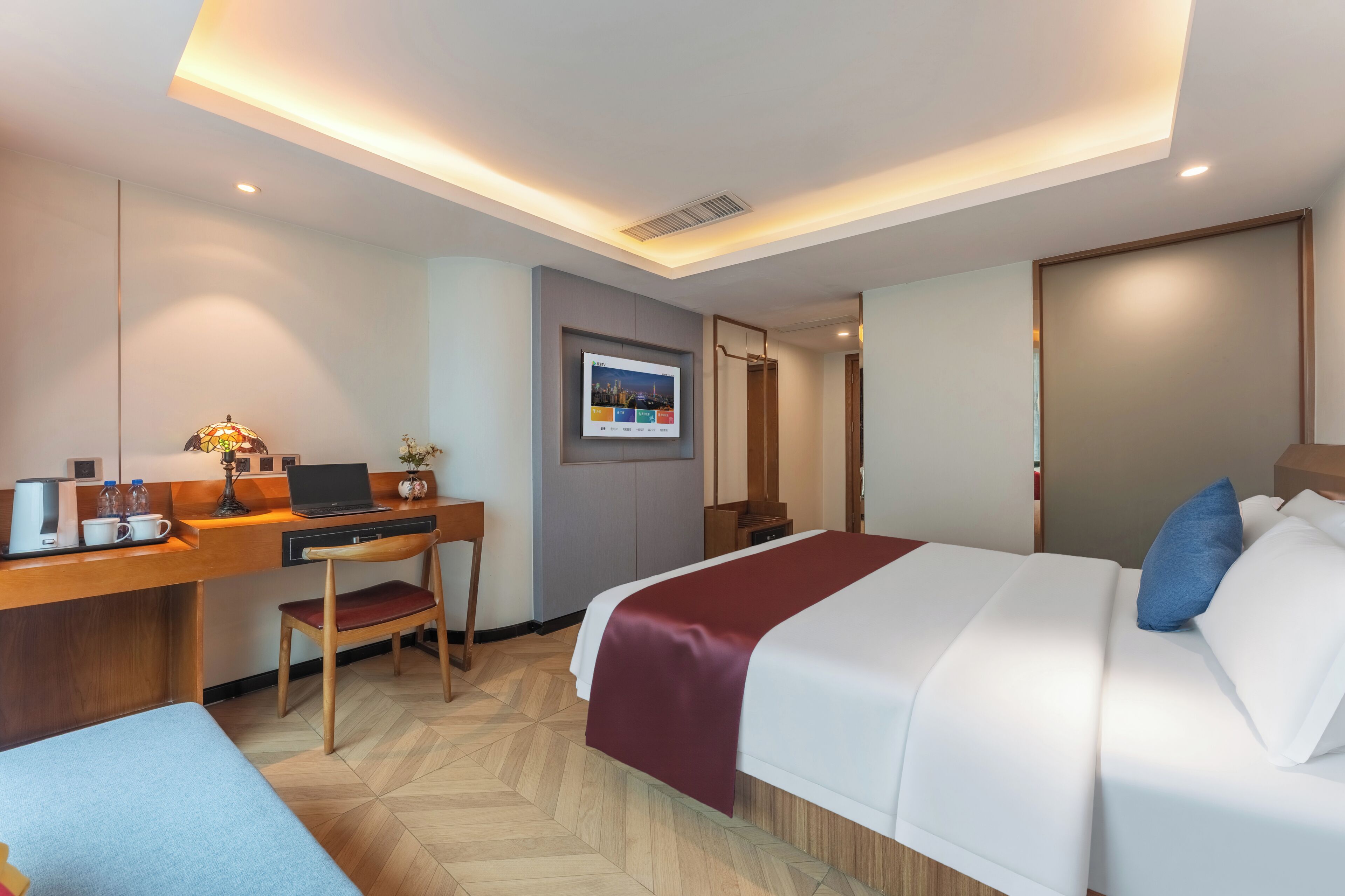 Habitación de hotel con cama, escritorio, silla y un pequeño rincón de descanso.