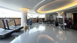 Un gimnasio moderno con cintas de correr, máquinas de pesas y suelo pulido.