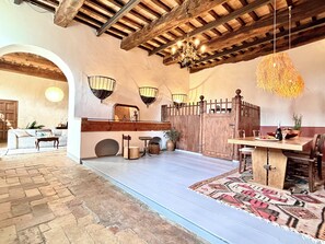 A rustic interior with exposed wooden beams, a dining area with a table and chairs, and a hanging light fixture. - Villa la scuderia quite luxury, pool and private garden near Florence (Toscana)