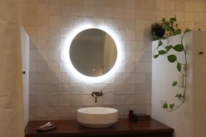 Een douche, handdoeken, zeep, toiletpapier