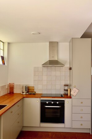 A kitchen with a stove, oven, and a range hood.