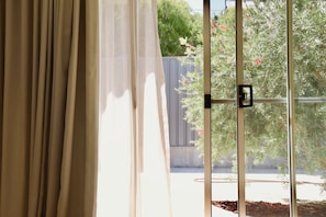 A window with a view of a tree and a fence. - Drift Studio at Prevelly Beach (Prevelly)