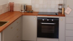 Een keuken met een fornuis, oven en een rvs-afzuigkap.