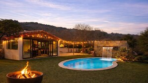 A backyard with a swimming pool, a fire pit, a covered patio, and a waterfall feature. - Luxury villa Lilly Aaron swimming pool and lake of sainte croix (Artigues)