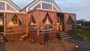 Ein zweistöckiges Holzhaus mit Balkon, nummerierten Zimmern und einem kleinen Garten.