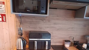 Eine kleine Küche mit Mikrowelle, Toaster, Kaffeemaschine und Geschirrspüler.