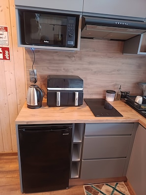 A compact kitchen with a microwave, toaster, coffee maker, and dishwasher.