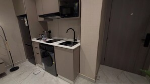 Une petite cuisine équipée d’un four à micro-ondes, d’un évier et d’un lave-vaisselle.