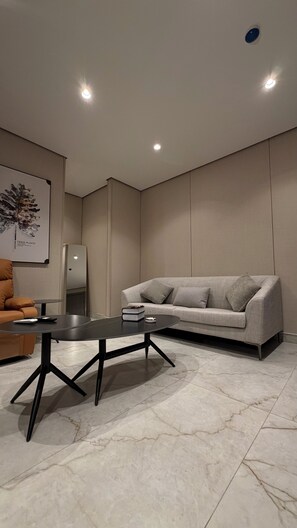 A modern living room with a sofa, a coffee table, and a framed picture on the wall. - 009 tara-JRE Jabal Al Lweibdeh with stunning view (Amman)
