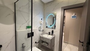 A modern bathroom with a glass shower enclosure, a vanity with a sink, and a mirror with a neon light. - 009 tara-JRE Jabal Al Lweibdeh with stunning view (Amman)