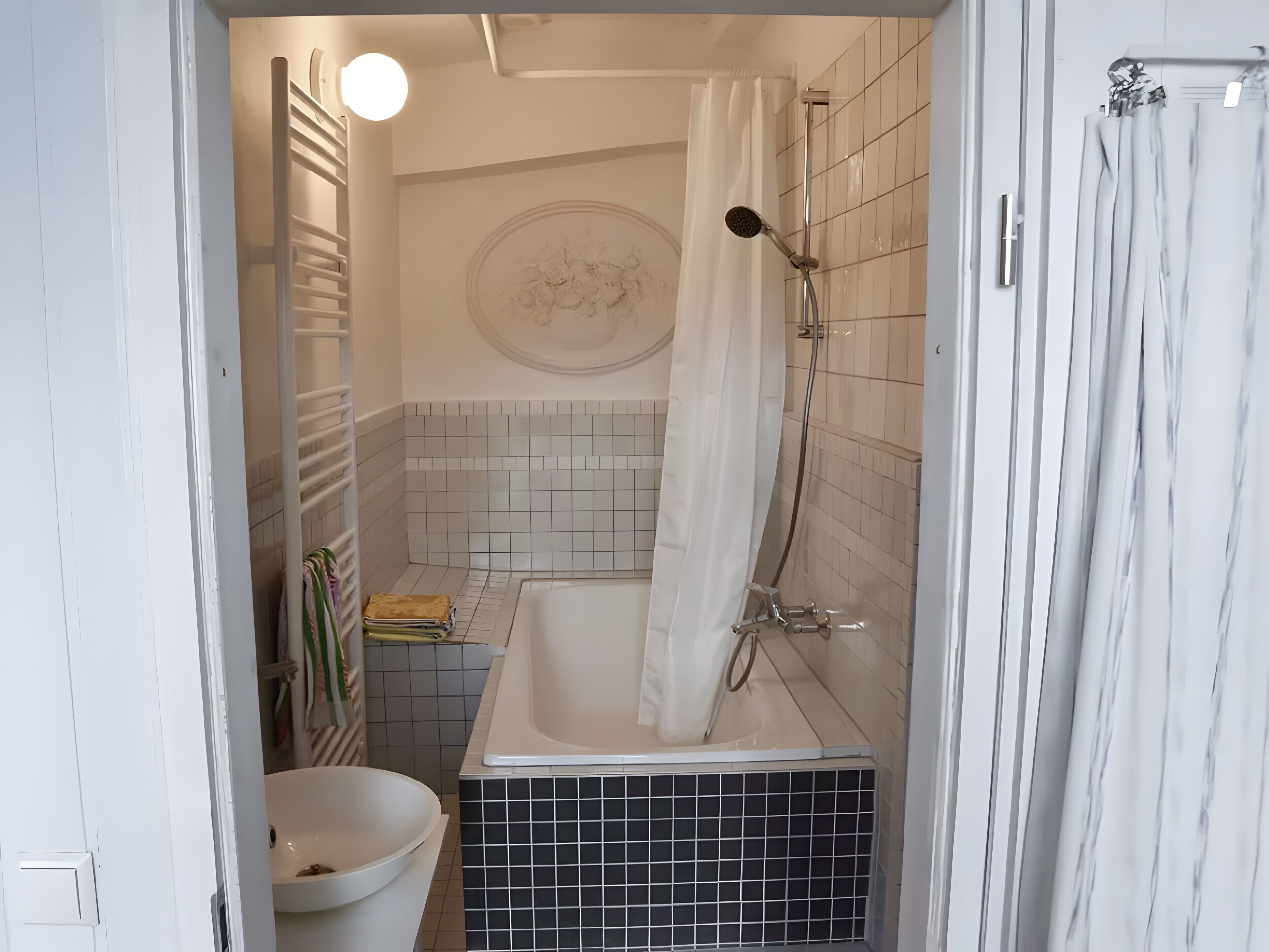 Et badeværelse med badekar, bruser og toilet.