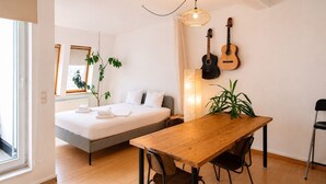 A modern bedroom with a bed, bedside table, and a dining area with chairs. - Vienna ROOF TOP Terrace APT (Wien)