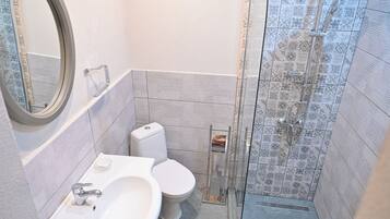 Un bagno con servizi igienici, lavandino e doccia.