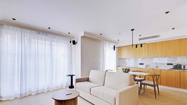 Un salon moderne comprenant un canapé, une table basse ronde et un coin repas avec une table et des chaises.