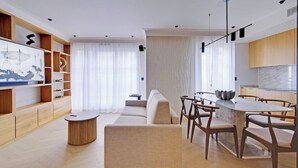 Un salon moderne comprenant un canapé, une table à manger et un coin cuisine.