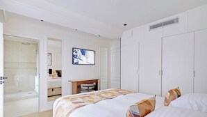Une chambre d’hôtel équipée d’un lit, d’un bureau, d’une chaise, d’une douche et d’une armoire.