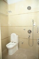 Un bagno piccolo e moderno con il water, una doccia e un porta carta igienica a parete.