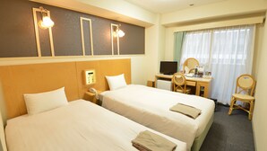 Une chambre d’hôtel avec deux lits, un bureau, une chaise, une télévision et un téléphone.