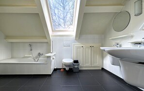 A modern bathroom with a skylight, a bathtub, a toilet, and a sink. - Nice home in Rendeux with WiFi (Rendeux)