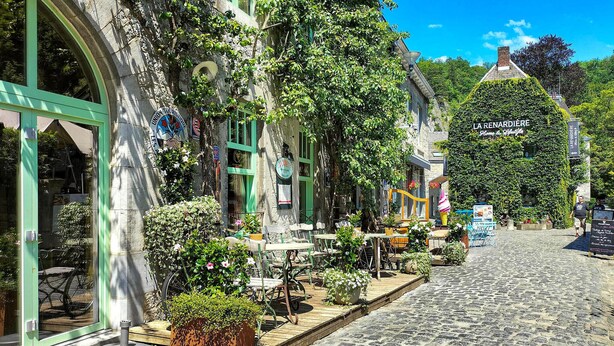 A cobblestone street with outdoor seating, a building with a green awning, and a sign for 'LA RENARDIE.' - Nice home in Rendeux with WiFi (Rendeux)