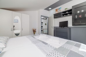 A bedroom with a bed, a wardrobe, a television, and a mirror. - Modern vacation home with a pool, Wi-Fi, and a barbecue (Grižane-Belgrad)