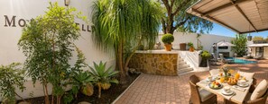 A patio area with a pool, outdoor seating, and a variety of plants. - Monte Bello Guesthouse (Windhoek)