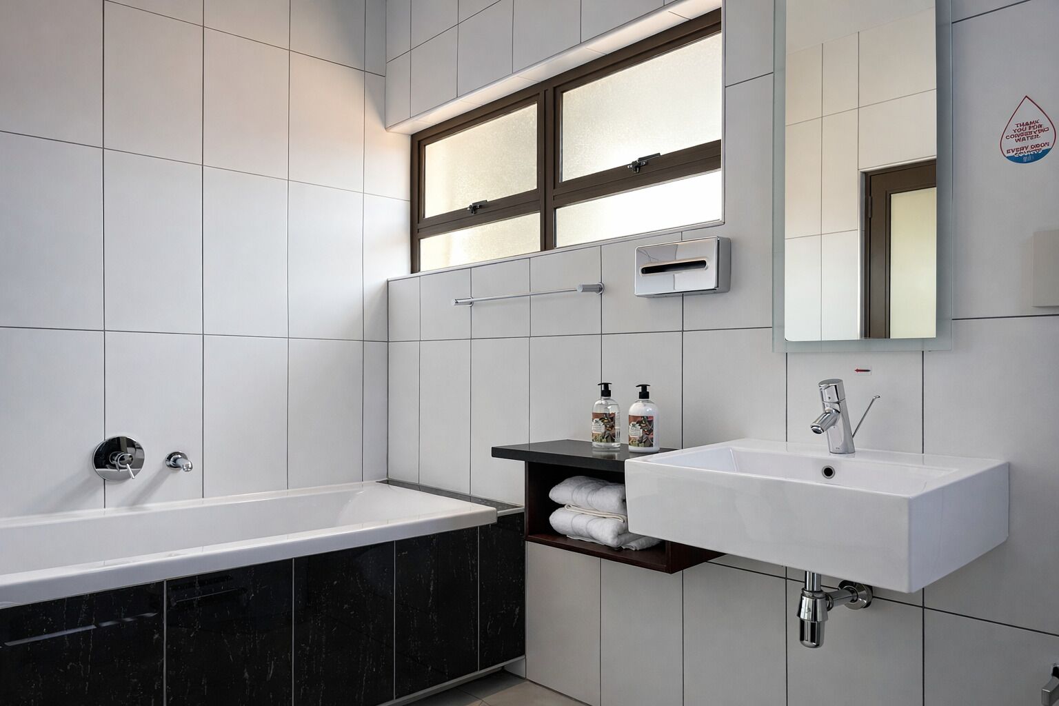 Une salle de bain moderne avec une baignoire, un lavabo et un miroir.