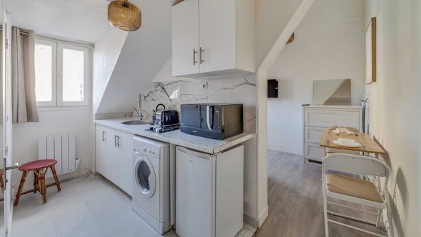 Eine kleine Küche mit Mikrowelle, Toaster und Waschmaschine.