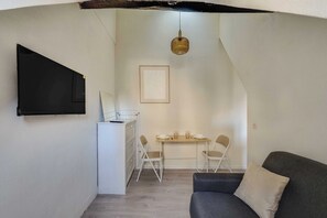A compact living space with a kitchenette, a dining area, and a sofa. - Charming studio - 2P- le Marais (Paris)