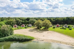 A rural landscape with houses, a pond, and trees. - Detached Lakeside Bungalow for 6 (Ewijk)