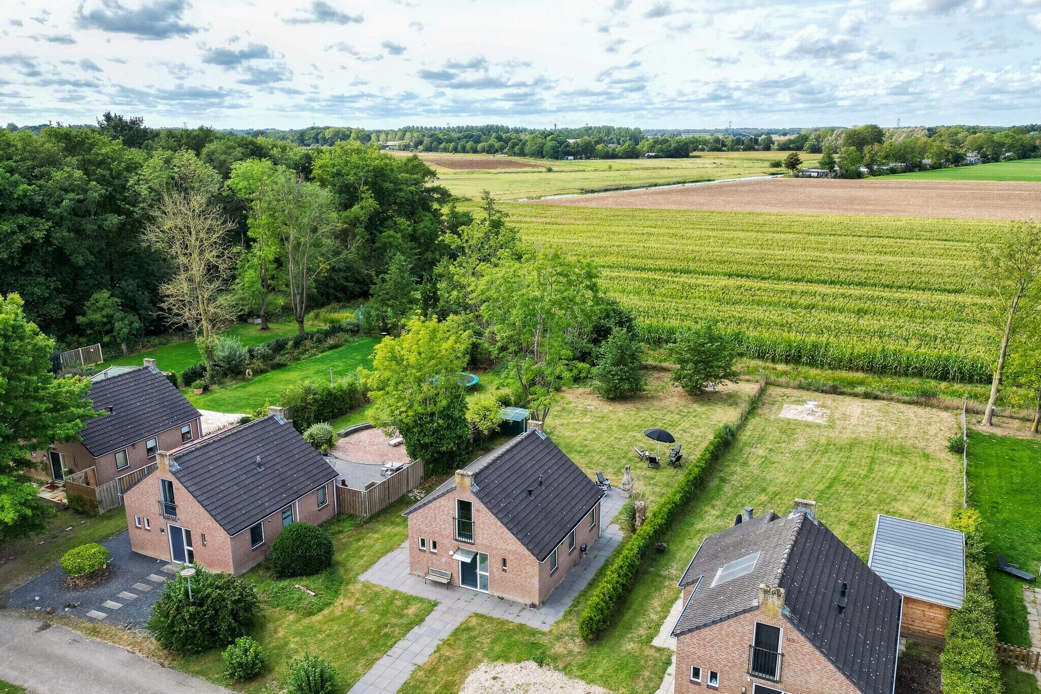 A residential area with houses, a lawn, and a field.