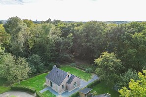 A house surrounded by dense forest, with a clear view of the property. - Serene Ewijk Abode by the Lake (Ewijk)